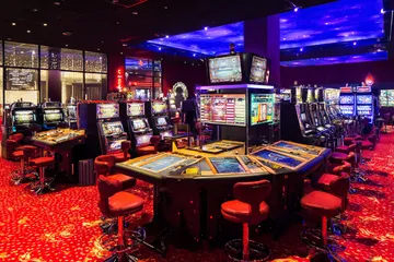 DB9 Slots — Thousands of exciting themes and jackpots A stylish woman beside vibrant slot machines displaying glowing sevens, showcasing the variety of top slots at DB9.