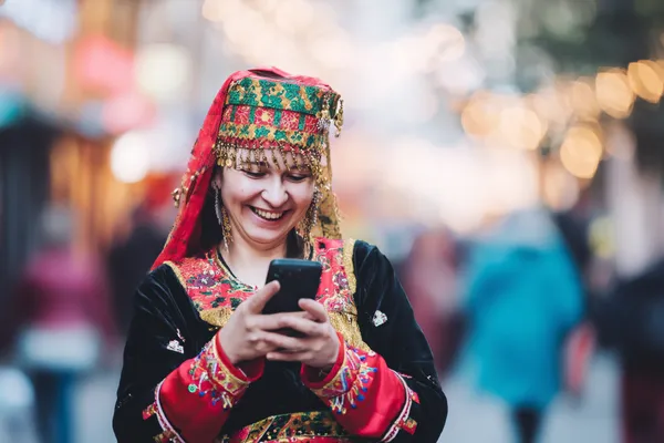 DB9 Mobile Casino — Play anytime, anywhere A player using their smartphone during a festive local event, representing DB9’s fully mobile-friendly casino.